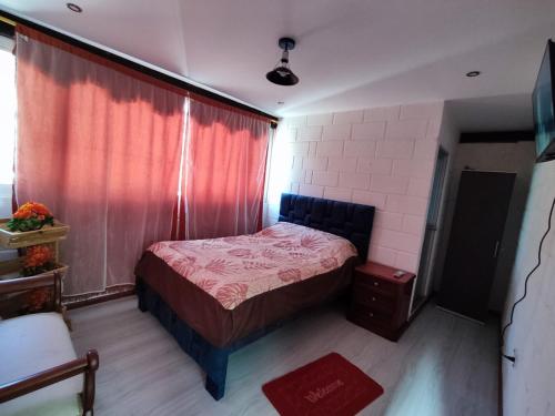 een slaapkamer met een bed en een rood gordijn bij Alojamiento Familiar MariaLuisa in Quillullaco