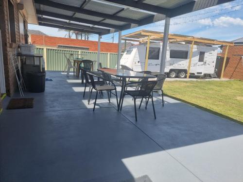 un patio con mesa, sillas y una cabaña en Two separate rooms in Clayton South, en Clayton North