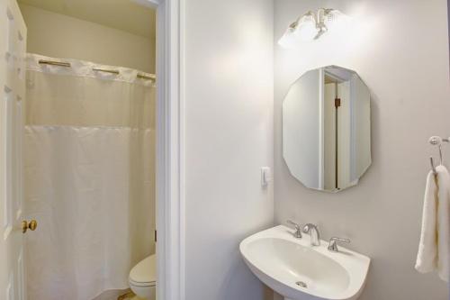 a white bathroom with a sink and a mirror at Anchorage Inn in Coupeville