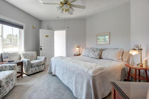 1 dormitorio con 1 cama, 1 silla y ventilador de techo en Anchorage Inn B&B, en Coupeville