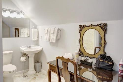W łazience znajduje się toaleta z umywalką i lustro. w obiekcie Anchorage Inn B&B w mieście Coupeville