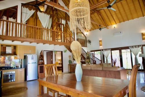 eine Küche und ein Esszimmer mit einem Holztisch in der Unterkunft Villa Sunset Beach in Gili Trawangan