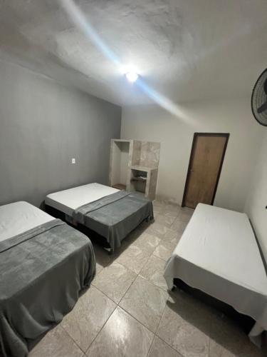 una camera con due letti e una luce sul soffitto di Cantinho da paz a Marechal Deodoro