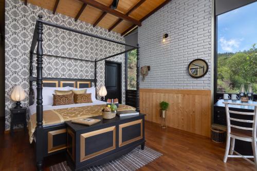 a bedroom with a bed and a table with a bar at The Capoe House in Haputale