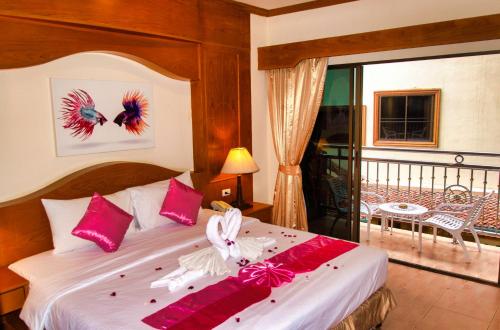 a bedroom with a bed with red and white decorations at Diva Patong Hotel in Patong Beach