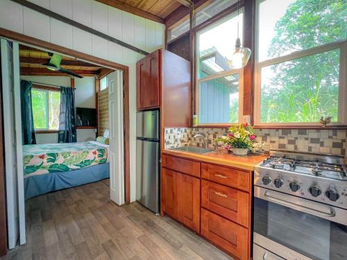 a kitchen with a sink and a stove and a bedroom at Hawaiian Sanctuary Eco Retreat Center in Pahoa