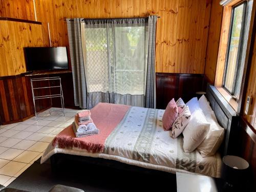 a bedroom with a bed with pillows and a window at Rustic Retreat Esperance in Esperance