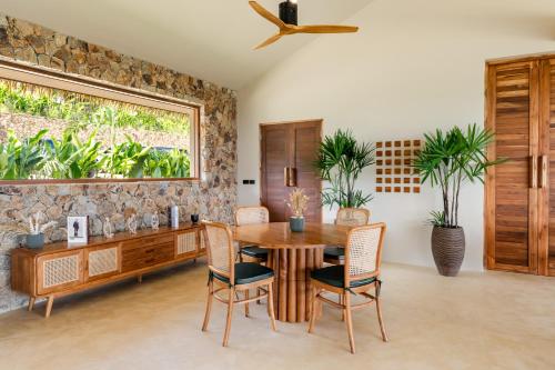 a dining room with a table and chairs and a window at Wild Cottages Elephant Sanctuary Resort in Amphoe Koh Samui