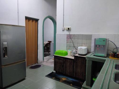 een keuken met een groene bar en een koelkast bij Yong's Stay Sri Manjung in Seri Manjung