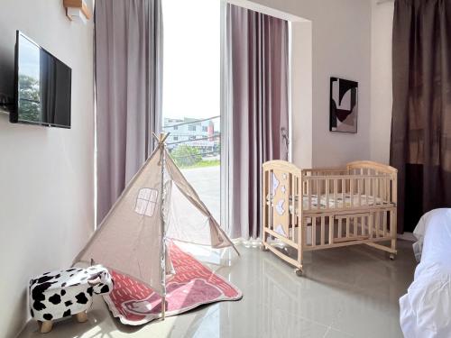 Habitación para bebés con cuna y habitación con ventana en Vilana Hotel en Arau