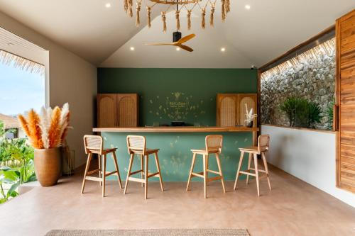 a kitchen with a green counter and stools at Wild Cottages Elephant Sanctuary Resort in Amphoe Koh Samui
