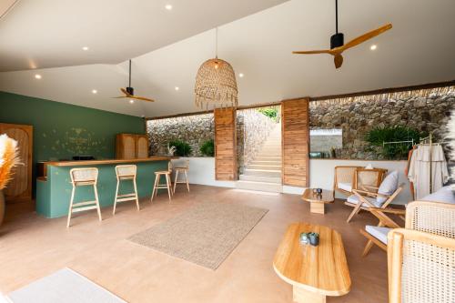 a living room with a bar and a table at Wild Cottages Elephant Sanctuary Resort in Amphoe Koh Samui