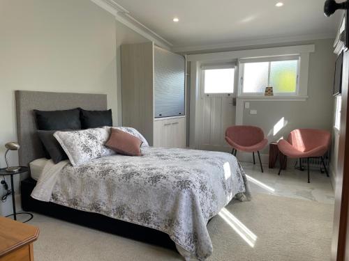 a bedroom with a bed and a table and chairs at Kowhai Studio in Paeroa
