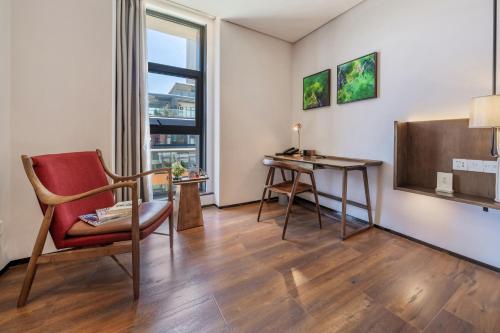 a living room with a chair and a desk at Wuyu Hotel - Chongqing Jiangbei Airport & Light Rail in Chongqing