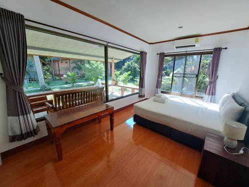 a bedroom with a bed and a large window at Baan Long Beach in Ko Lanta
