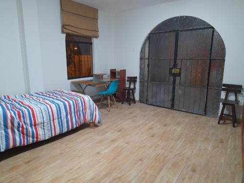 Terraza más habitaciones en La Molina في ليما: غرفة نوم بسرير وباب مقوس مع طاولة