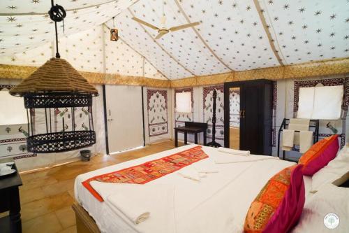 a bedroom with a large bed in a room at Sam Sand Dunes Desert Safari Camp in Jaisalmer