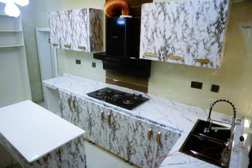eine Küche mit weißen Marmoroberflächen und einem Herd in der Unterkunft Luxury Charming 5Bed Duplex With Starlink wifi - Lekki in Ikuata