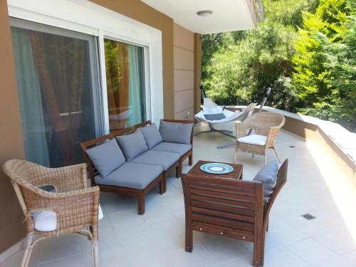 a patio with a couch and chairs on a porch at Villa Anna Maria in Kriopigi