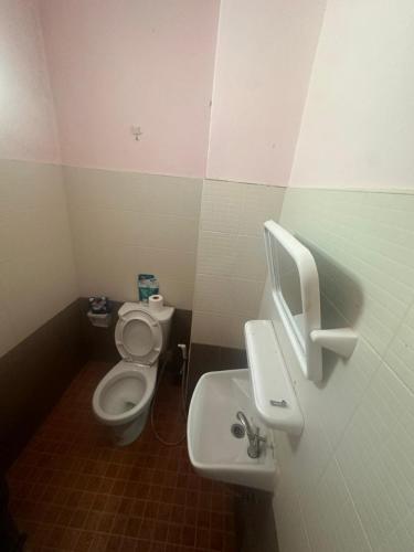a small bathroom with a toilet and a sink at T&R Wagner Appartaments in Patong Beach
