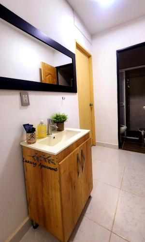 een badkamer met een wastafel en een spiegel aan de muur bij 101 Cerca al estadio in Medellín