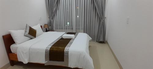 1 dormitorio con cama grande y ventana grande en Khách sạn 68 ĐỒNG HẢI, en Dong Hoi