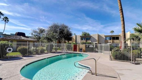 ein Pool in einem Garten mit einem Zaun in der Unterkunft Comfy 1-Bdrm Condo in Heart of Old Town Scottsdale in Scottsdale
