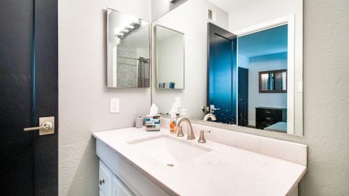 Baño blanco con lavabo y espejo en Contemporary Condo in Hub of Old Town Scottsdale en Scottsdale