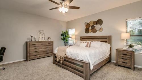 - une chambre avec un lit et un ventilateur de plafond dans l'établissement Massive 5 bdrm Getaway wPool, Hot Tub, Game Room, à Gilbert