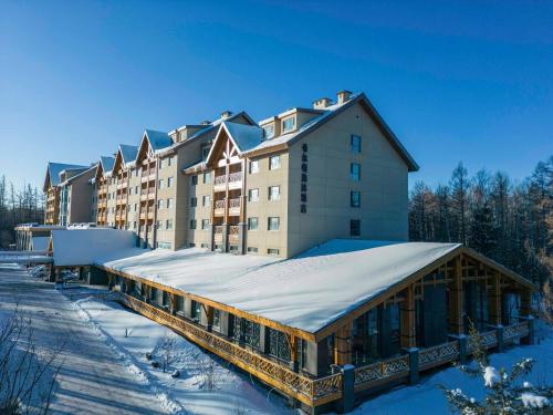 a hotel in the snow with a building at DoubleTree by Hilton Changbaishan Hot Spring in Antu