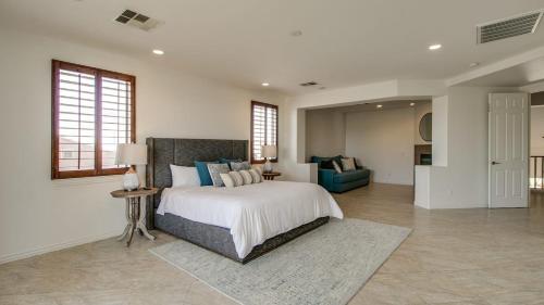 um quarto com uma cama grande e uma sala de estar em Amazing Litchfield Estate With Backyard Oasis em Litchfield Park