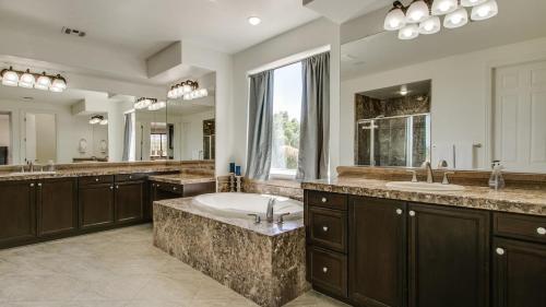 un ampio bagno con due lavandini e una grande vasca di Amazing Litchfield Estate With Backyard Oasis a Litchfield Park