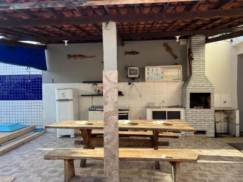 una cocina con una gran mesa de madera en una habitación en Cantinho da paz, en Marechal Deodoro