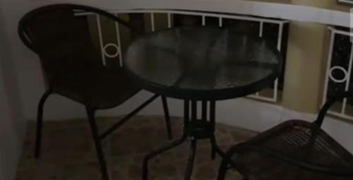a glass table and a chair in a room at Eagles Nest Villa House AC TV WIFI Fan Luxury Modern in Albion