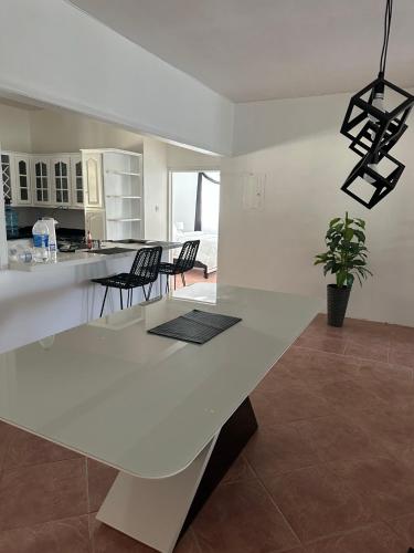 a white kitchen with a large white table and chairs at Eagles Nest Villa House AC TV WIFI Fan Luxury Modern in Albion