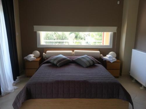 a bedroom with a large bed with a window at Villa Anna Maria in Kriopigi