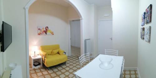 ein Wohnzimmer mit einem gelben Sofa und einem Tisch in der Unterkunft Casa MATERA - Bilocale Terminal Bus in Termoli