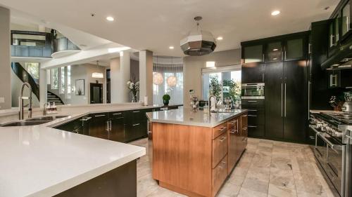 a large kitchen with black cabinets and white counter tops at Stunning Private and Modern N Scottsdale Estate in Scottsdale