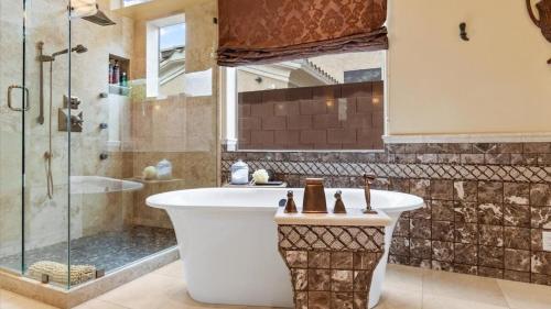 a bathroom with a bath tub and a shower at Southwestern 4 Bdrm Retreat HTD Pool Game Room in Phoenix