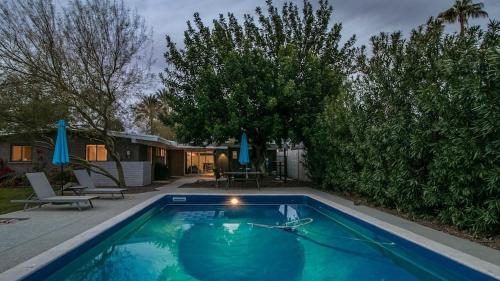 a swimming pool with a hose in a yard at Mid-Century Modern wBackyard Oasis Putting Green in Phoenix