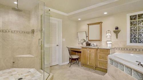 a bathroom with a shower and a tub and a sink at The Palm in Scottsdale