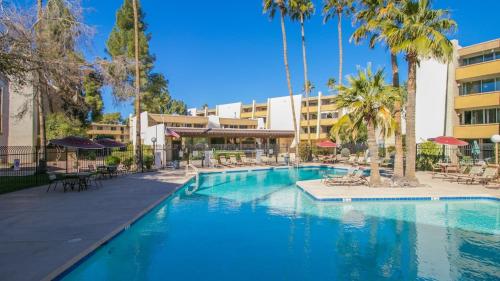 a large swimming pool with palm trees and a building at Cozy 2-Bdrm Condo in Heart of Old Town Scottsdale in Scottsdale