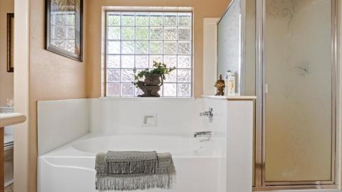 una vasca bianca in un bagno con finestra di New listing Charming 4 bedroom with Pool a Peoria