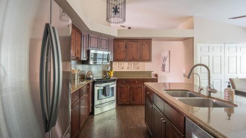 a kitchen with wooden cabinets and a stainless steel refrigerator at Scottsdale Gem wPool in Private and Serene Yard in Scottsdale