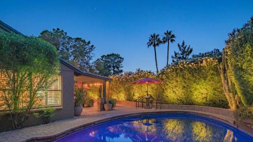 a swimming pool in a backyard with a table and an umbrella at Scottsdale Gem wPool in Private and Serene Yard in Scottsdale