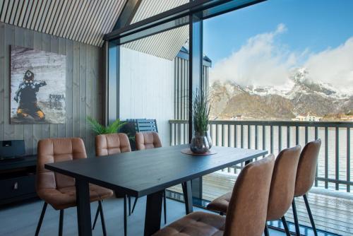 una sala da pranzo con tavolo e sedie su un balcone di CornerView Apartment Henningsvær a Henningsvær