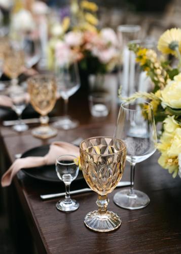 a wooden table with wine glasses and flowers on it at Crama Mircesti in Mirceşti