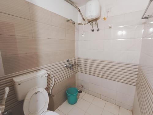 een badkamer met een toilet en een blauwe emmer bij Goroomgo Deep Ganga Inn Near Sea Beach Puri in Puri
