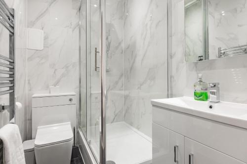 a white bathroom with a shower and a sink at Pembroke Heights in Chatham