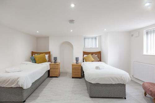 two beds in a room with white walls at Pembroke Heights in Chatham